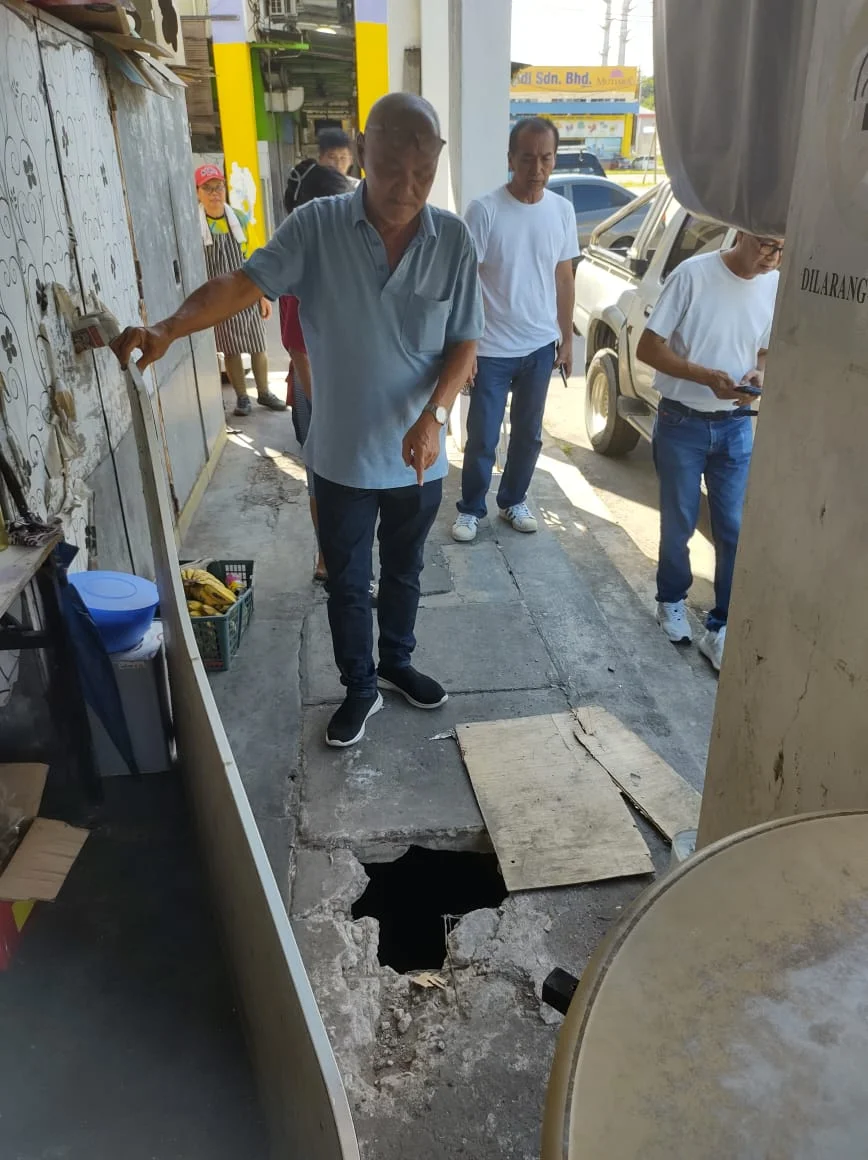 Sam Koh Chik Ping showing the broken slab that require repair at New Jia Hua Coffeeshop (Grand Industrial Centre)